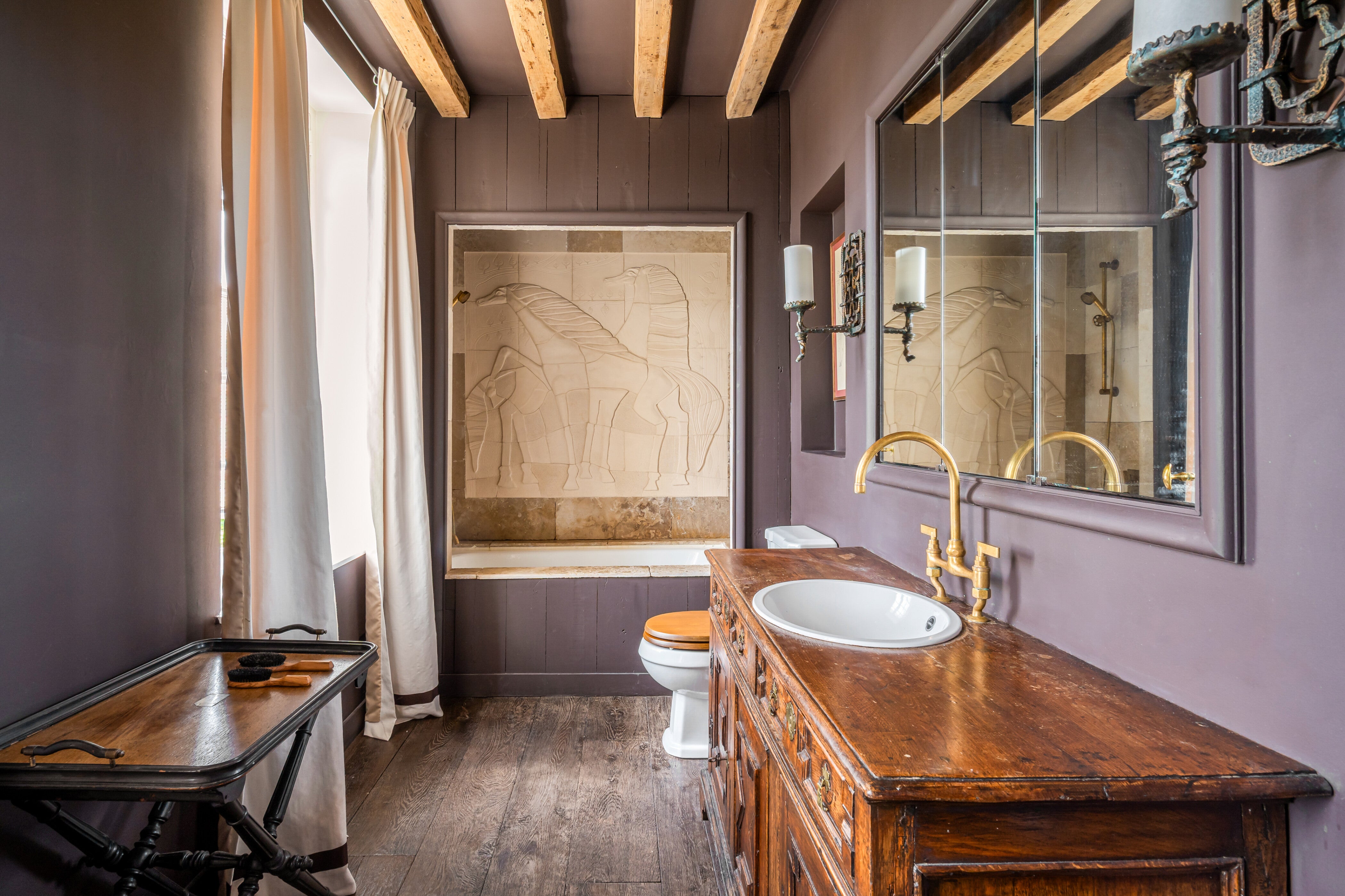 Primary bathroom in this paris home. Featuring vintage woods and aged brass fittings.