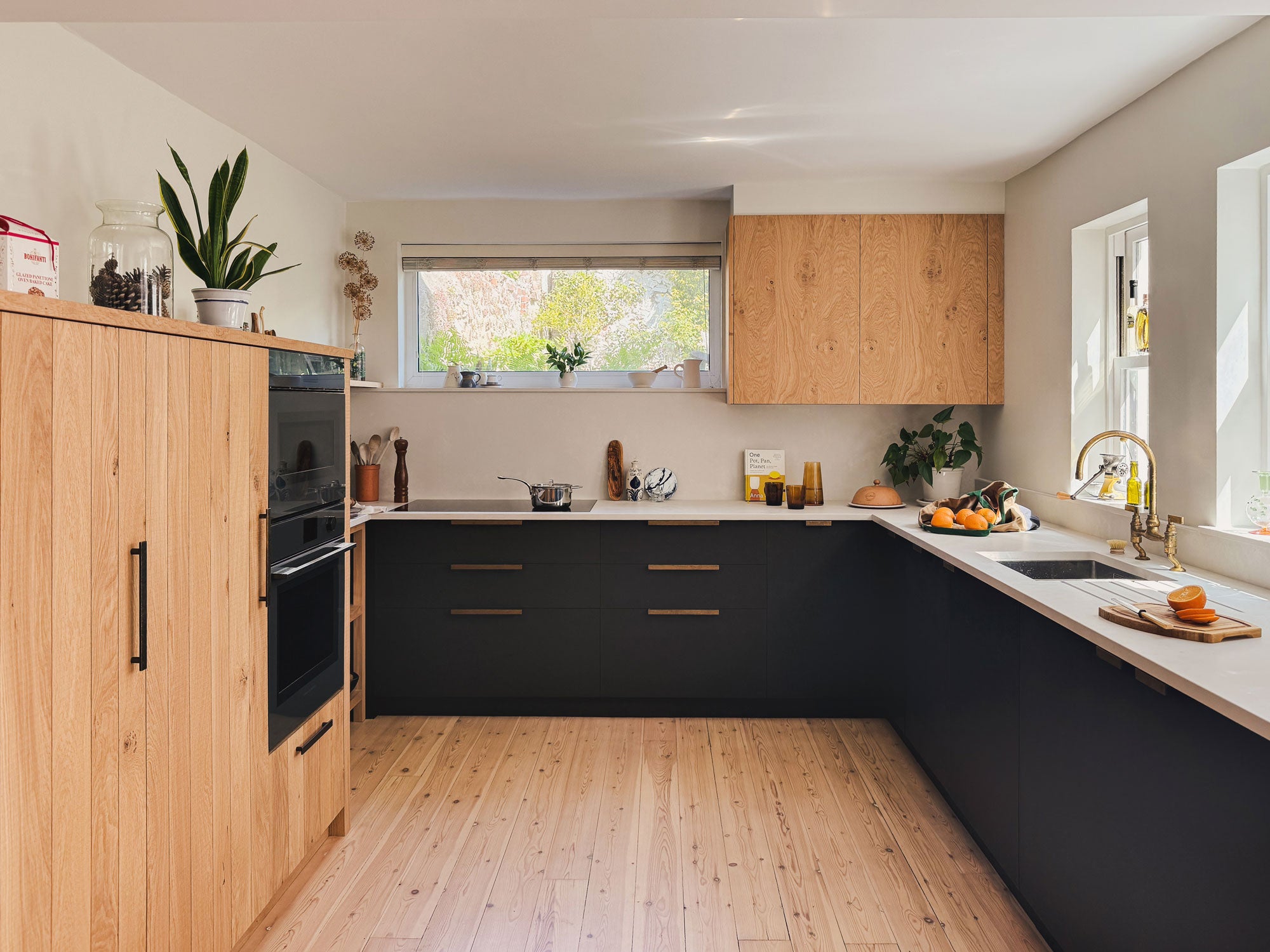 Richlite cupboards, Caesarstone worktops, Armac Martin handles and Studio Ore's kitchen bridge mixer tap make up this kitchen design. An oak wall cupboard provides clever storage. 