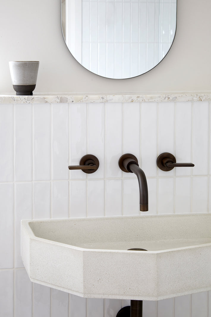 Studio Ore brass bathroom taps in lacquered bronze are found in the bathroom.