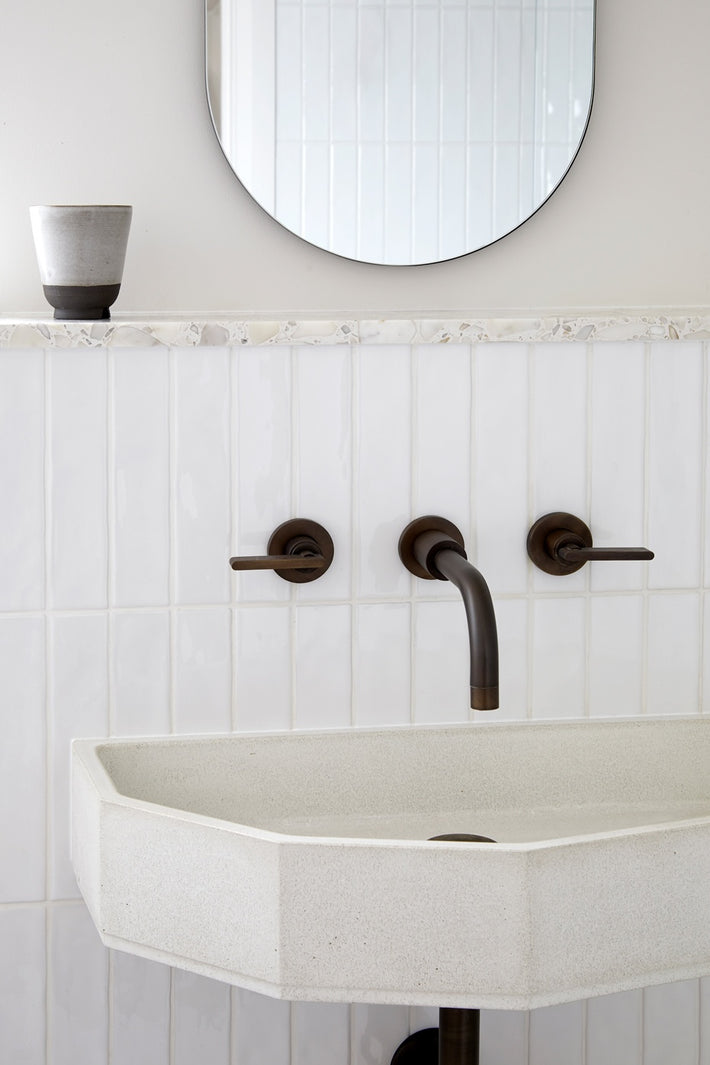 Studio Ore's solid brass wall-mounted basin tap in a bronze finish. 
