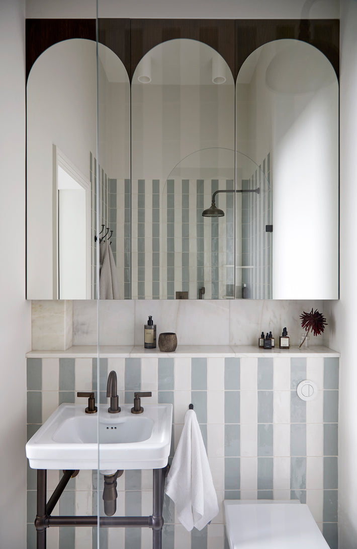 Studio Ore's brass fittings are featured in this project's secondary bathroom. All in lacquered bronze are deck mounted basin taps and overhead shower. 