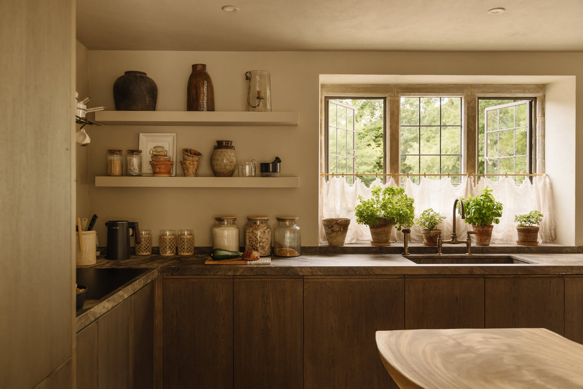 Studio Ore's deck-mounted kitchen bridge mixer and hand rinse stand over a wide basin.