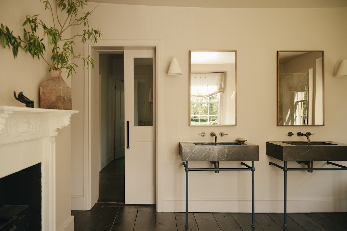 a pair of Studio Ore basin taps in unlacquered bronze are found in the primary bathroom.