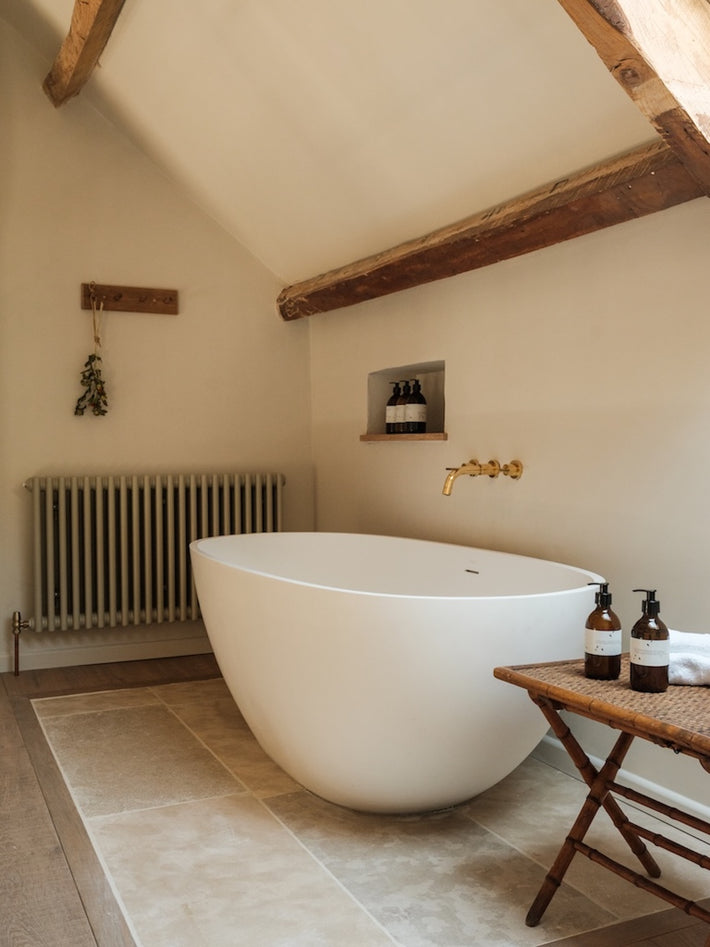 Ensuite bathroom at Osip, featuring Studio Ore's Three Hole Wall Mounted Bath Tap in unlacquered polished brass.