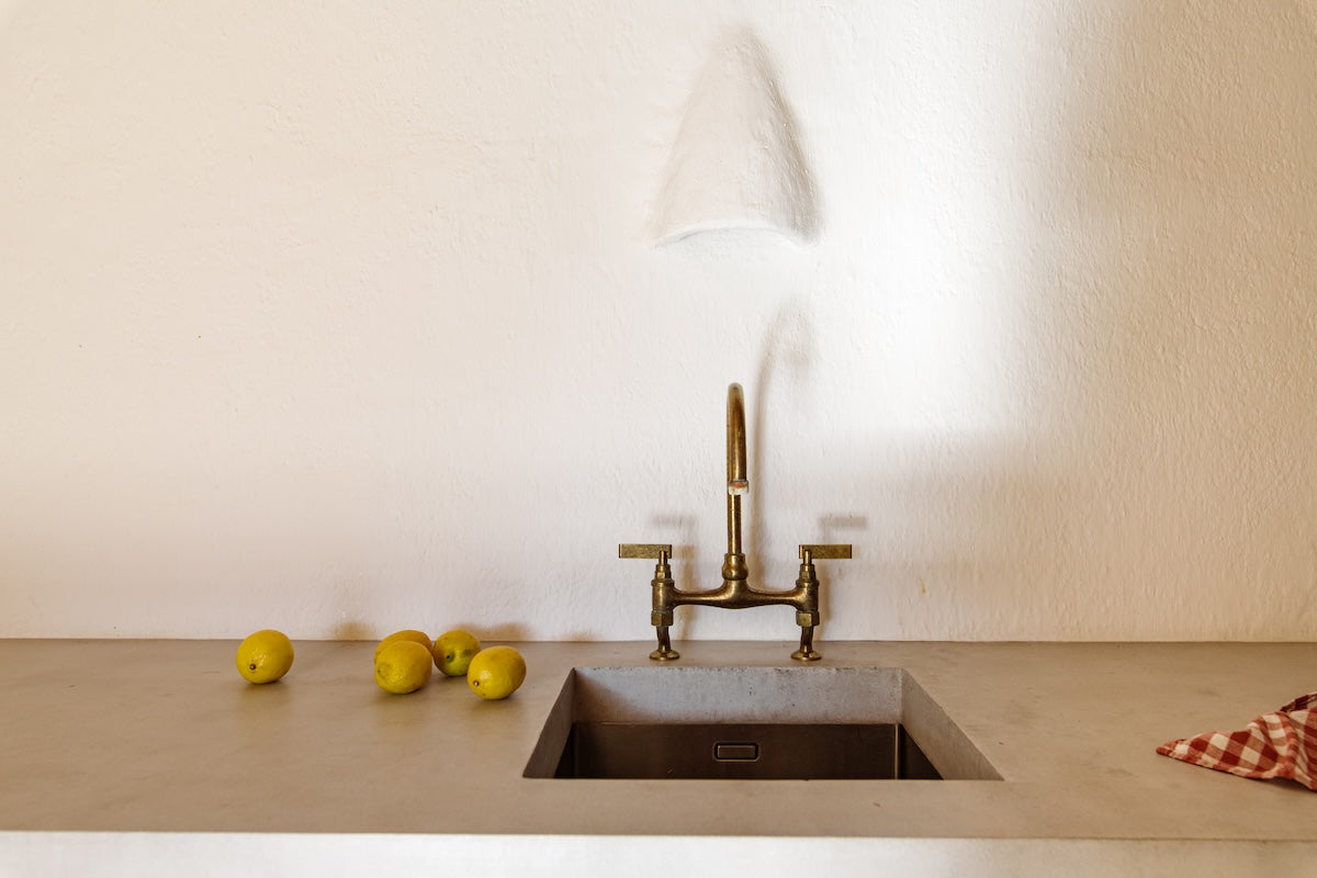 Studio Ore fittings are found in this project in Ibiza by Harry Clark Interiors. Here, in the pared-back kitchen, is our kitchen bridge mixer in unlacquered polished brass. It's developed a rich, characterful patina. 