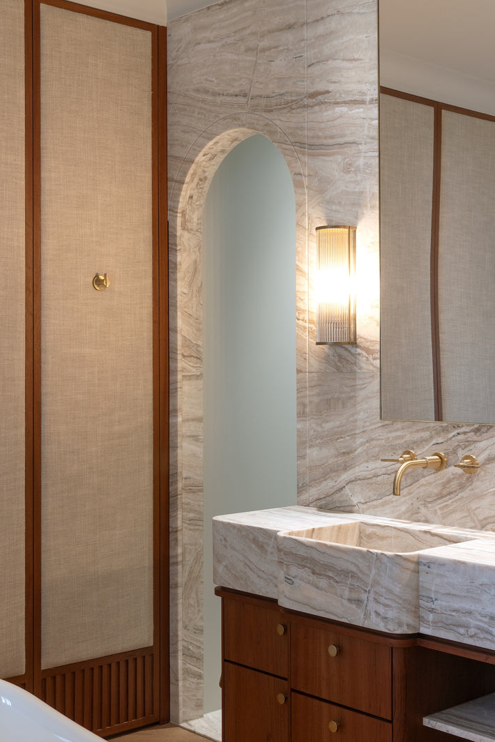 A modern marble basin with Studio Ore's unlacquered brushed brass basin tap.