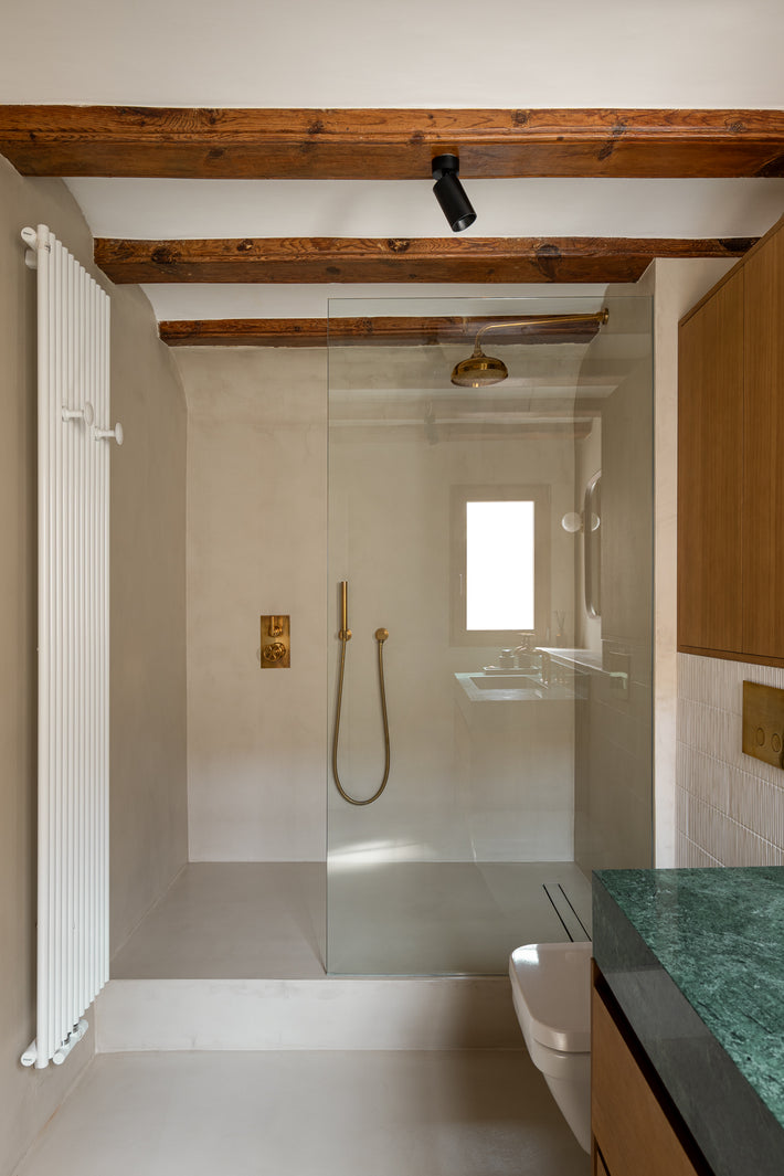 Studio Ore's solid brass shower fittings and accessories are found in the bathroom of this Barcelona apartment.