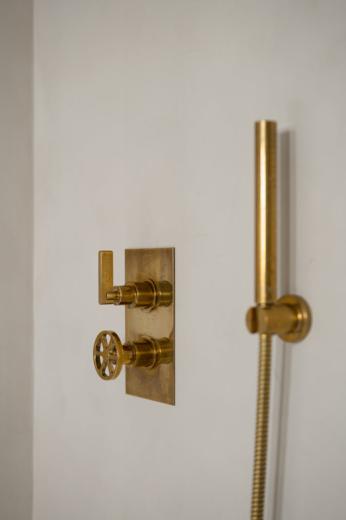 Studio Ore's solid brass shower fittings and accessories are found in the bathroom of this Barcelona apartment. Here, the thermostat with two way diverter, and hand shower, have developed a natural patina. 