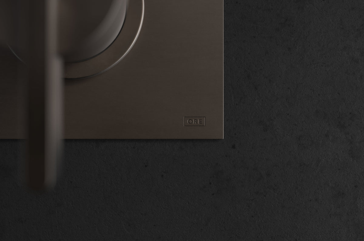 Studio Ore Chapter Three Two Hole Wall Mounted Basin Mixer with Angled Spout and Backplate with Cross handle in bronze, short spout, detail view