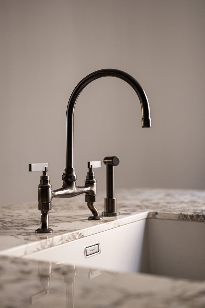 Studio Ore's kitchen bridge mixer tap and kitchen hand rinse in lacquered bronze.